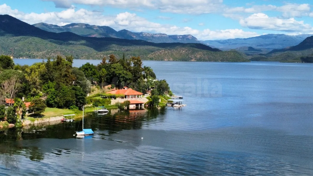 Vista aérea de una casa junto al Dique Cabra Corral con el agua cubriendo parte de su estacionamiento.