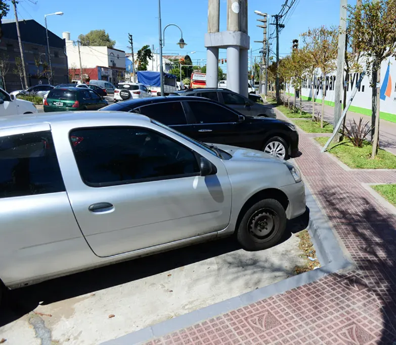 Autos estacionados sobre la vereda.