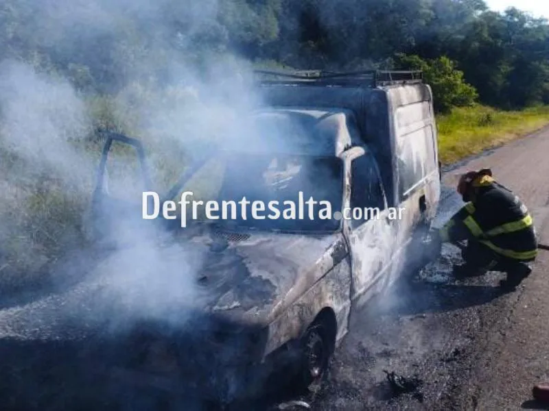 Bomberos trabajan en el vehículo incendiado.