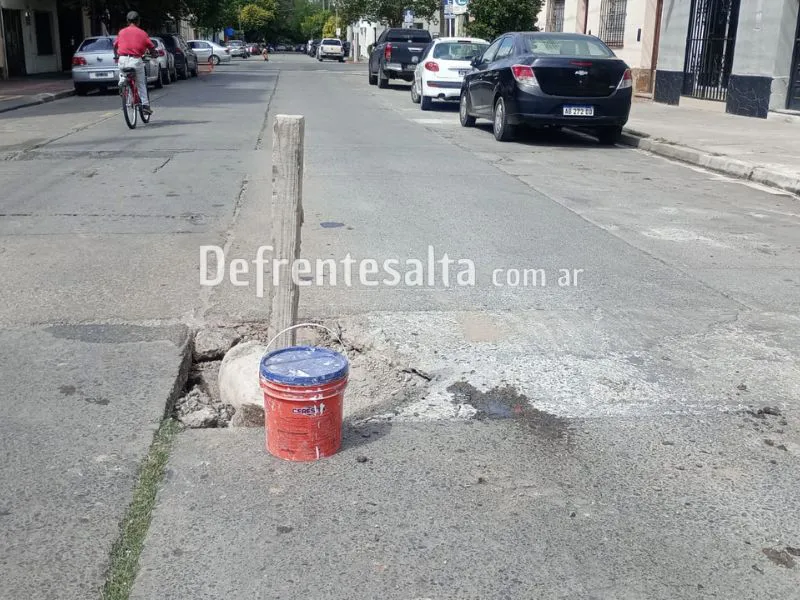 Tacho de pintura y un poste.