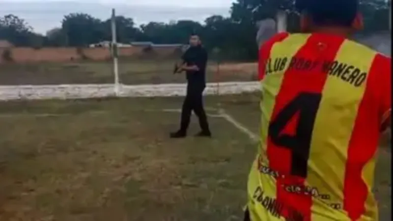 Policía saca su arma para defenderse de hinchas.